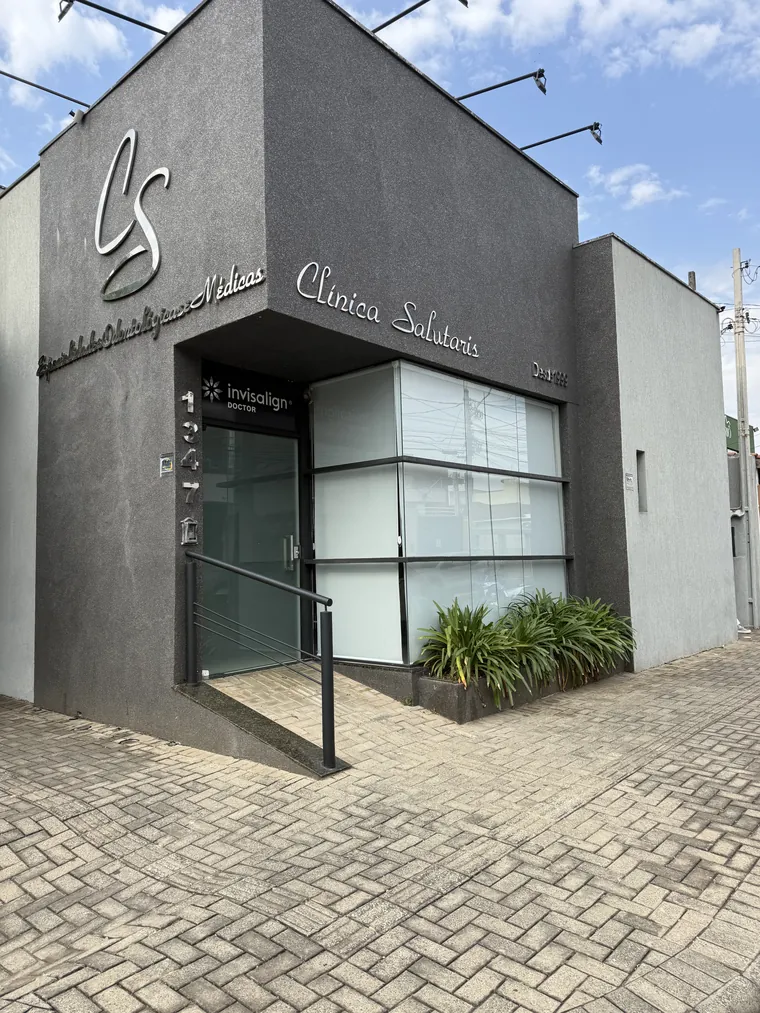 Entrada da Clínica Salutaris: a porta de vidro abrindo para a recepção